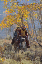 USA, Wyoming, Big Horn Mountains, reitendes Cowgirl und Cowboy im Herbst - RUEF001331