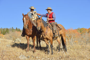 USA, Wyoming, Big Horn Mountains, reitendes Cowgirl und Cowboy im Herbst - RUEF001322
