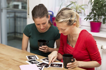 Schwangere Frau und Freundin beim Betrachten von Ultraschallscans - MIDF000020