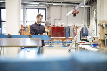 Young technician working in an industrial hall - SGF001281