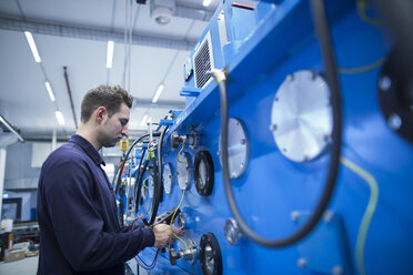 Young technician controlling electric energy in an industrial hall - SGF001282