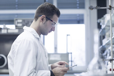 Chemist working in lab with digital tablet - SGF001286