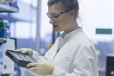 Biologist in laboratory holding rack - SGF001254