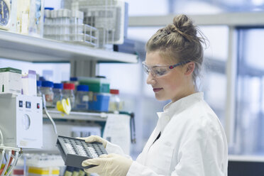 Biologist in laboratory holding rack - SGF001255