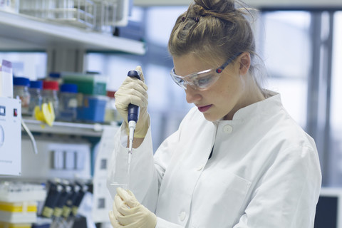 Biologe bei der Arbeit im Labor mit Pipette, lizenzfreies Stockfoto