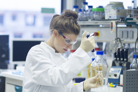 Biologist working in laboratory with pipette stock photo