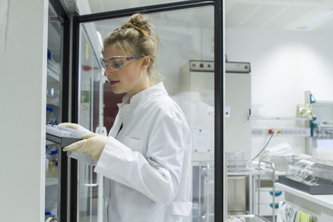 Biologe im Labor mit Regal, lizenzfreies Stockfoto