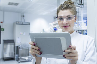 Porträt eines Wissenschaftlers im Labor, der ein digitales Tablet hält - SGF001266