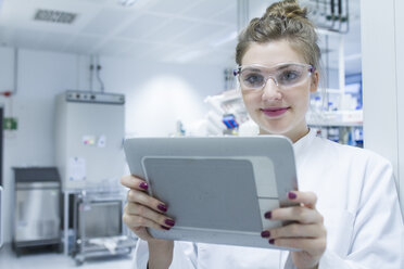 Portrait of scientist in laboratory holding digital tablet - SGF001266