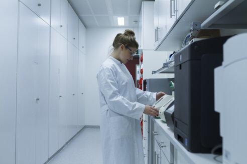 Biologist in laboratory looking at device - SGF001269