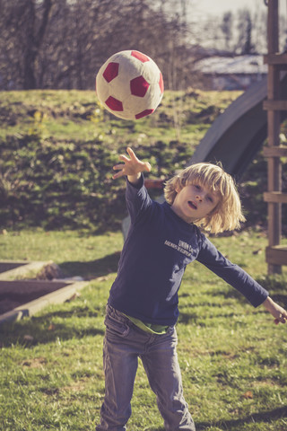 Kleiner Junge wirft einen Ball, lizenzfreies Stockfoto