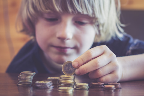 Little boy counting coins stock photo