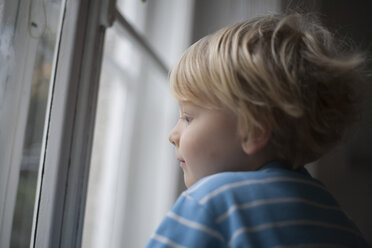 Profil eines kleinen Jungen, der aus dem Fenster schaut - RB002214