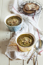 Bowls of Saag spiced with chili flakes on cloth - SBDF001537