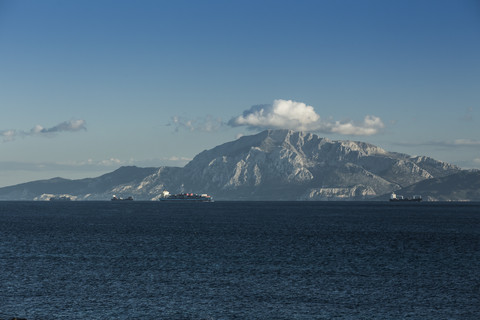 Spanien, Andalusien, Tarifa, Frachtschiffe passieren die Straße von Gibraltar vor dem Berg Moses, lizenzfreies Stockfoto