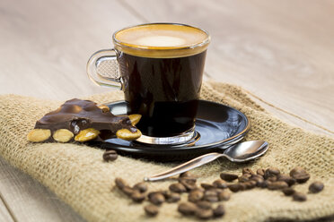 Hausgemachte dunkle Schokolade mit ganzen Nüssen, Kaffeebohnen und einer Tasse Espresso auf Jute - JUNF000112