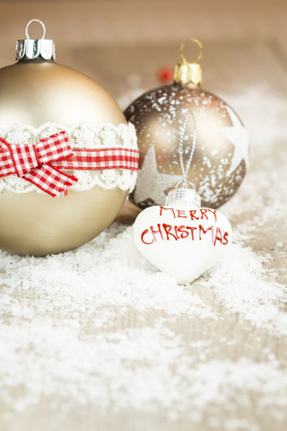 Drei verschiedene Weihnachtskugeln auf künstlichem Schnee, lizenzfreies Stockfoto