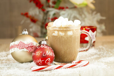 Christmas baubles, sugar cane and glass of hot chocolate with cream and marshmallows on artifical snow - JUNF000122