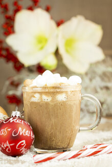 Weihnachtskugel, Zuckerrohr und ein Glas heiße Schokolade mit Sahne und Marshmallows auf Kunstschnee - JUNF000123
