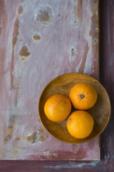 Three oranges on wooden plate and wooden board - MYF000776