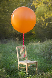 Stuhl mit Luftballon auf der Wiese - JTLF000017