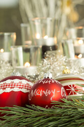 Christmas decoration, Red christmas baubles and candles in the background - JUNF000137