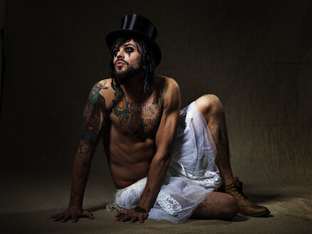 Portrait of man with full beard and eye make up wearing top hat and totu - STK001128