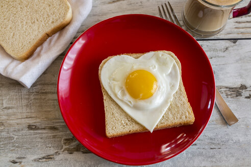 Heart-shaped fried egg on toast on red plate - SARF001190
