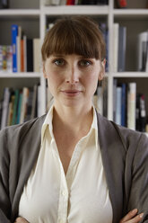 Portrait of woman in front of book shelf - STKF001140