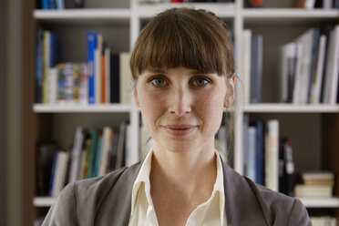 Portrait of woman in front of book shelf - STKF001141