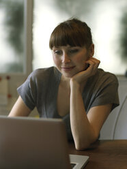 Woman at desk using laptop - STKF001174