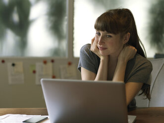 Woman at desk using laptop - STKF001176