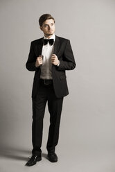Porträt eines jungen Mannes in schwarzem Anzug, weißem Hemd und Schleife - UUF003029