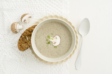 Creme of mushroom soup in white soup bowl, baguette slice - ECF001636