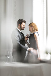 Elegant couple with red wine glasses in restaurant - WESTF020386