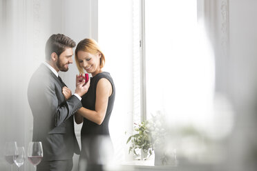 Elegant couple with engagement ring in restaurant - WESTF020392