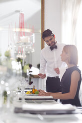 Kellner serviert einer Frau in einem eleganten Restaurant das Abendessen - WESTF020416