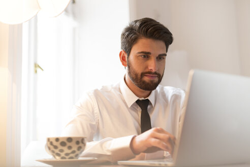 Geschäftsmann mit Laptop und Tasse Kaffee - WESTF020474