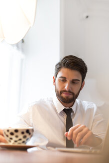 Geschäftsmann mit Laptop und Tasse Kaffee - WESTF020477