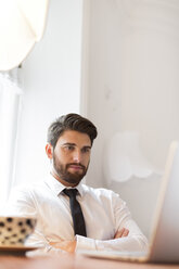 Geschäftsmann mit Laptop und Tasse Kaffee - WESTF020478