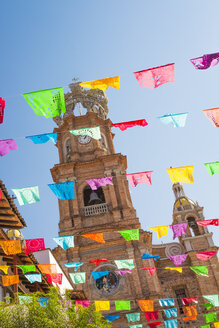 Mexico, Jalisco, Puerto Vallarta, Colorful flags, Tower of the Church of Our Lady of Guadalupe in the background - ABAF001597