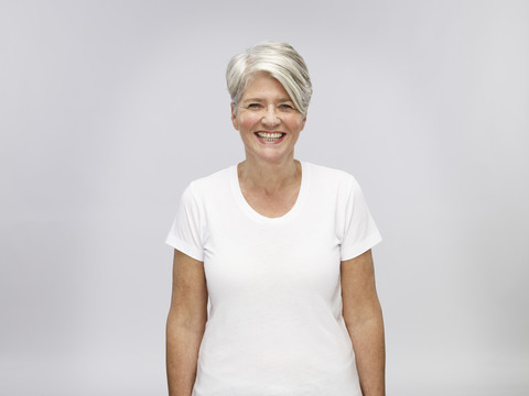 Porträt einer reifen Frau mit grauem Haar vor einem hellen Hintergrund, lizenzfreies Stockfoto