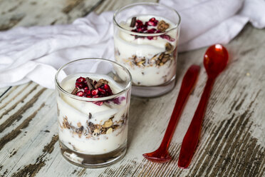 Two glasses of natural yoghurt with granola, chocolate shaving and pomegranate seeds - SARF001206