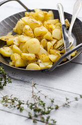 Gusseiserne Bratpfanne mit Bratkartoffeln auf Holz - ODF000922