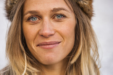 Portrait of smiling blond wearing fur cap - TCF004474