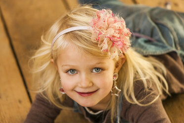 Porträt eines lächelnden blonden kleinen Mädchens mit Haarband - TCF004484