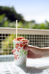 USA, Hawaii, Big Island, Pepeekeo, Hand hält Pappbecher mit Fruchtsmoothie - BRF000970