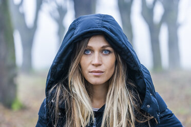 Portrait of serious looking blond woman with blue hood - TCF004500