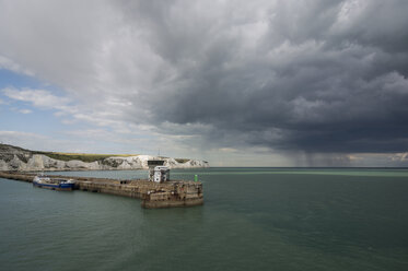 Großbritannien, England, Dover, Frachtschiff im Hafen, White Cliffs und Sturm im Hintergrund - PAF001111