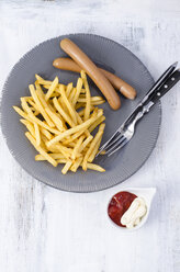 Dish of Wiener and French Fries and dipping bowl of Mayonnaise and Ketchup on wood - ODF000962